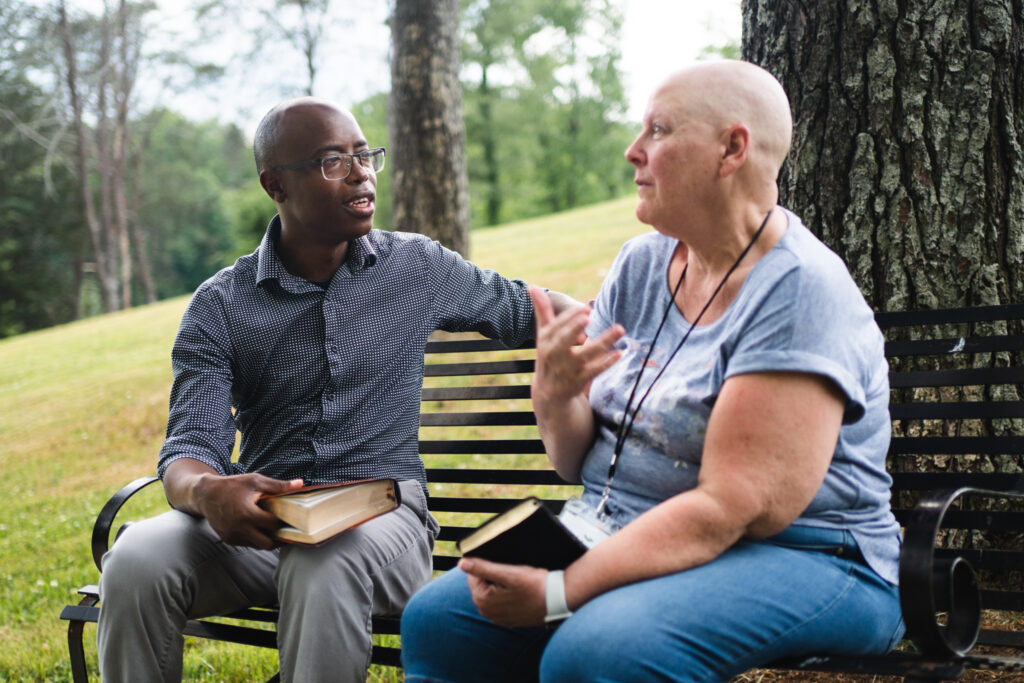A Wildwood team member and guest talking together on an outdoor bench
