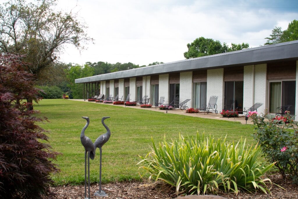 Wildwood guest lodging with a long covered walkway and landscaped lawn